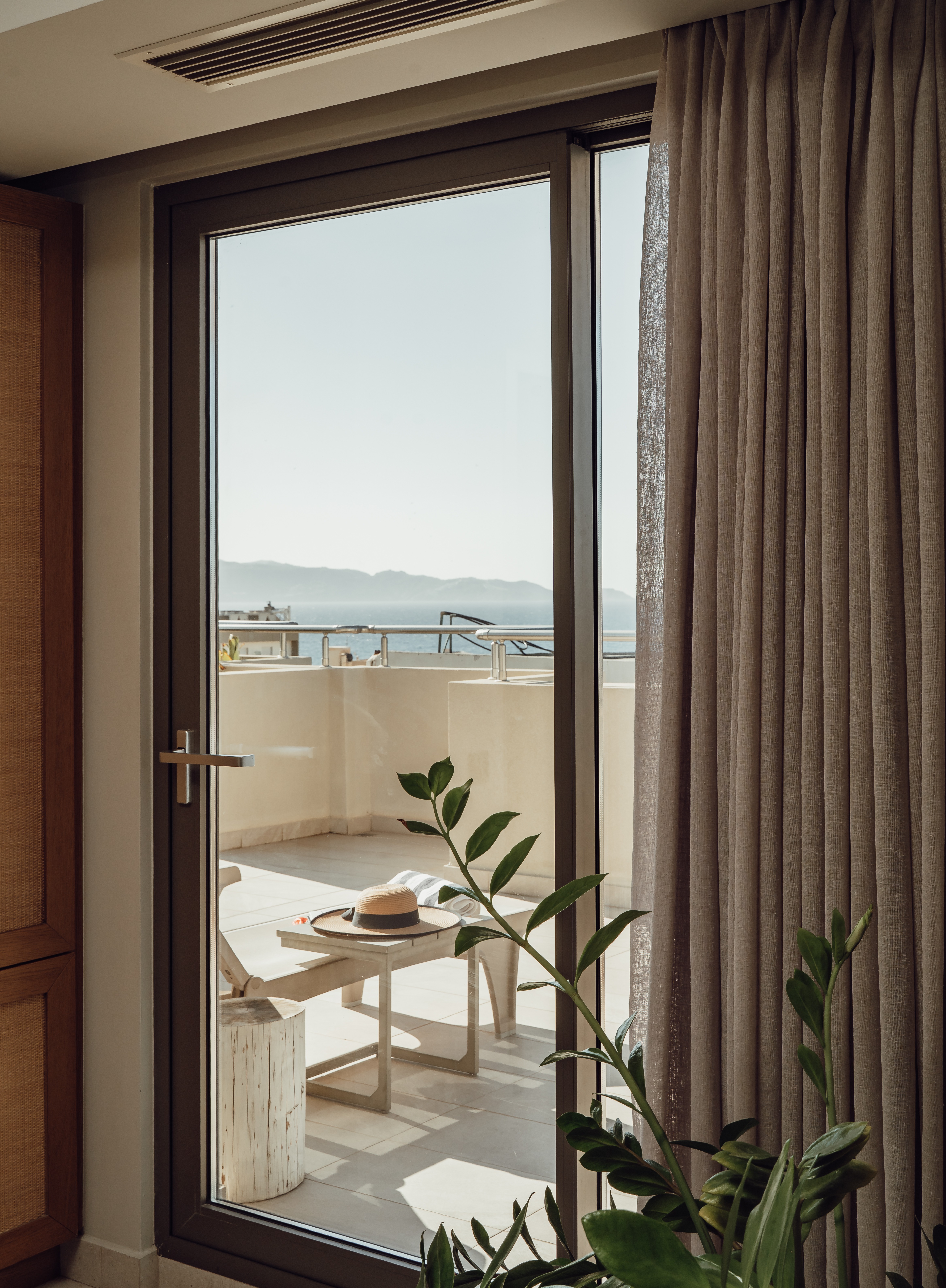 The Junior Suite's private terrace, with loungers, a hanging chair and the hot tub